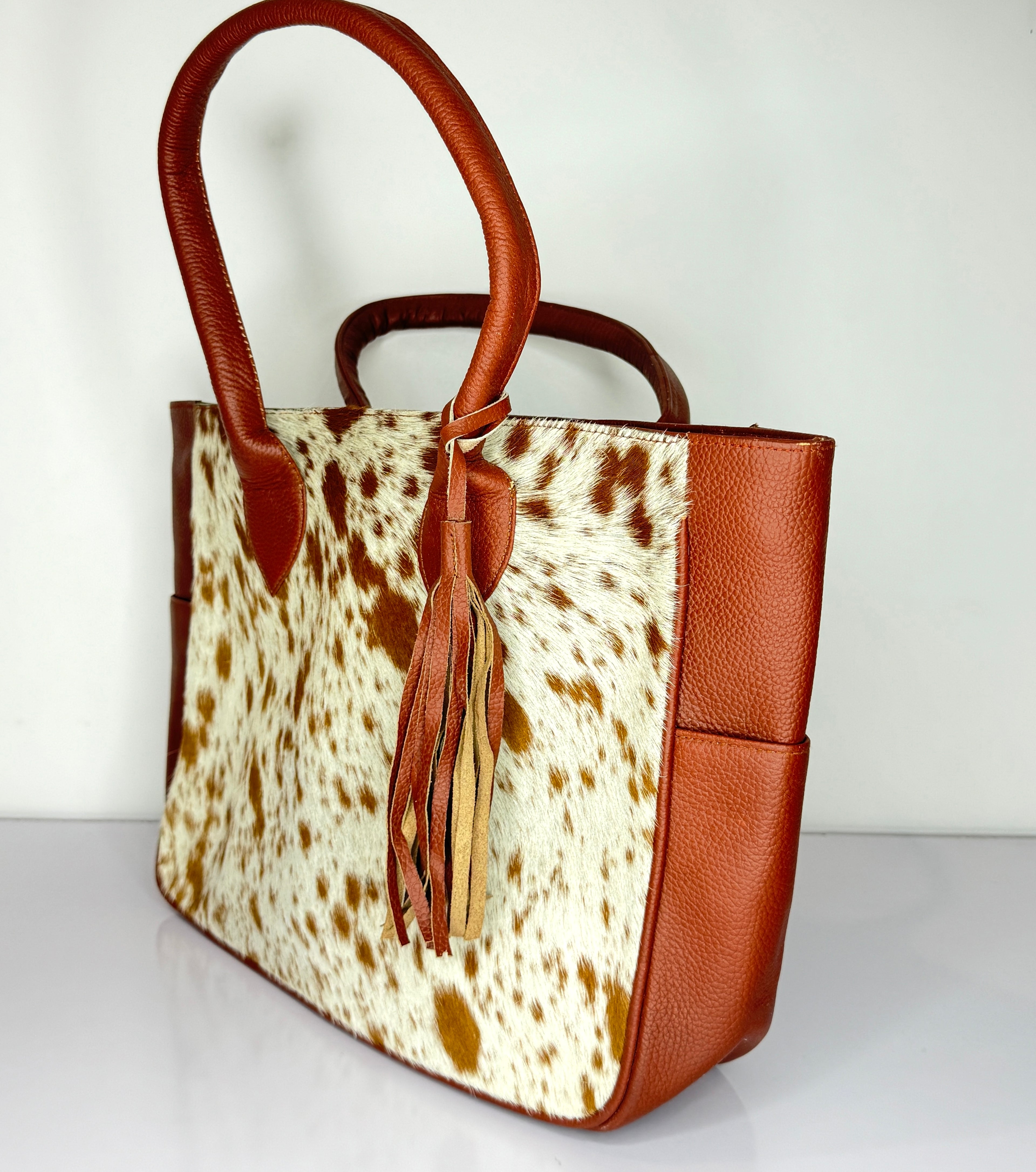 Tan And White Cowhide Leather Tote Bag with Tassel Accent